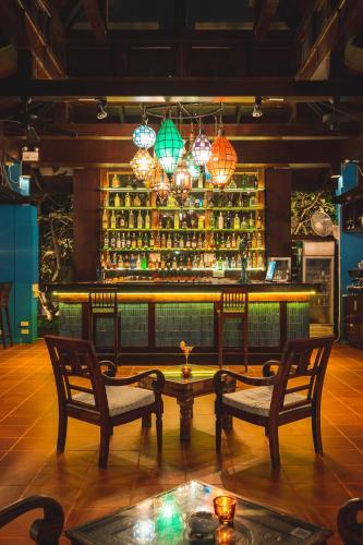 a bar with two chairs and a table and some lights at Burasari Phuket Resort & Spa in Patong Beach