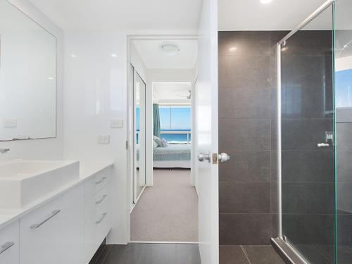 a bathroom with a walk in shower next to a bed at Ocean Plaza Unit 936 in Gold Coast