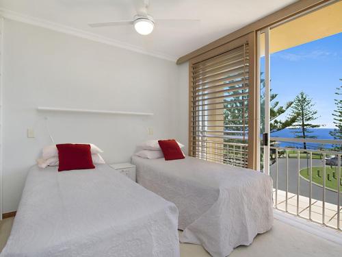 a bedroom with two beds and a window with a view at Orion Unit 7 in Gold Coast