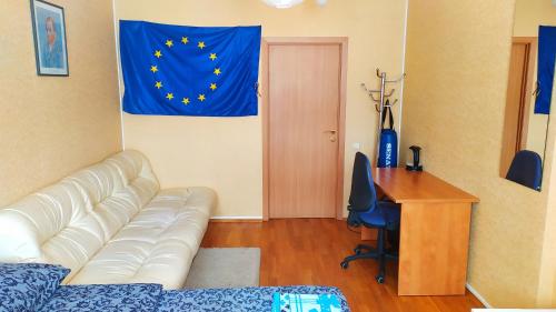 a living room with a couch and a desk and a flag at Alaska Fox in Kyiv