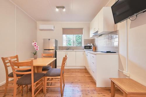 a kitchen with a wooden table and a dining room at Ruthven Street Motor Inn in Toowoomba