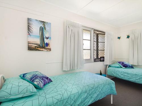 a bedroom with two beds and a picture on the wall at Tondio Terrace Flat 2 in Gold Coast