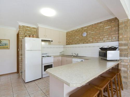 
a kitchen with a refrigerator, stove, sink and a dishwasher at Tumut Unit 1 - Great unit in a central location to beaches, clubs and shopping in Coolangatta
