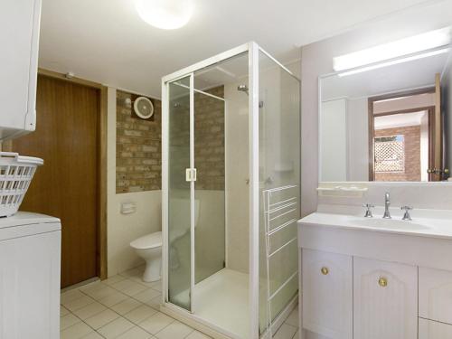 a bathroom with a shower and a sink and a toilet at Tumut Unit 1 in Coolangatta