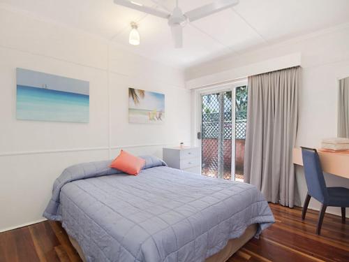 a bedroom with a bed and a desk and a window at Tondio Terrace Flat 5 - Pet friendly and close to the beach in Gold Coast