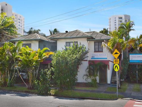 a white house with a street sign in front of it at Tondio Terrace Flat 5 - Pet Friendly in Gold Coast