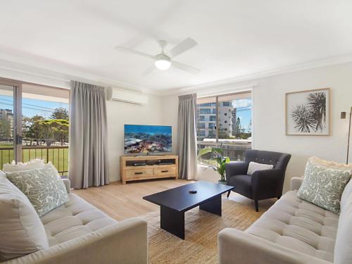 
a living room filled with furniture and a tv at Tumut Unit 2 - Great unit in a central location to beaches, clubs and shopping Wi-Fi included in Coolangatta
