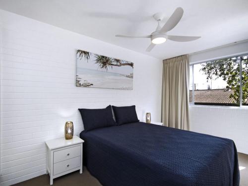 a bedroom with a blue bed and a window at White Caps Unit 3 in Gold Coast