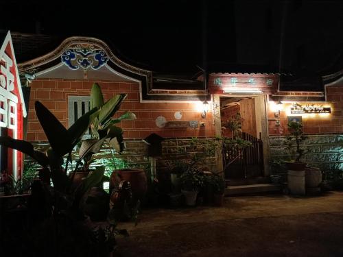 a house with plants in front of it at night at 彼岸古厝民宿-包棟優先--Biiann B&B in Jinning