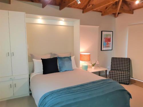 a bedroom with a large bed and a chair at Port Central No 2 in Port Campbell