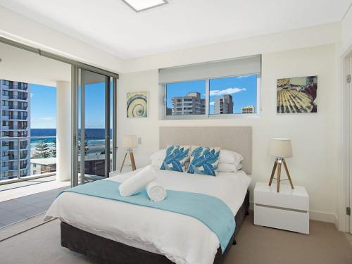 - une chambre avec un grand lit et un balcon dans l'établissement Eden Apartments Unit 901, à Gold Coast