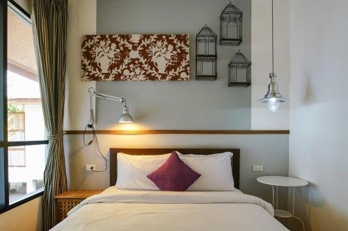 a bedroom with a bed with a red pillow at Koh Munnork Private Island in Ko Munnork