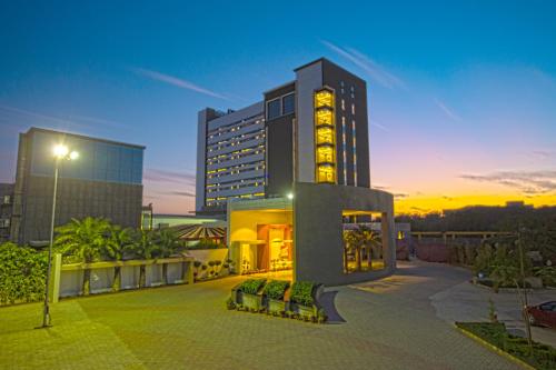 a building with a lit up tower in a city at Hotel Kasturi Orchid in Pāl