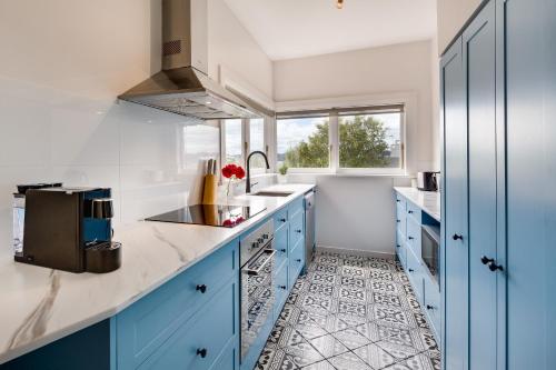 a kitchen with blue cabinets and a sink at Maison del Mar in Hobart
