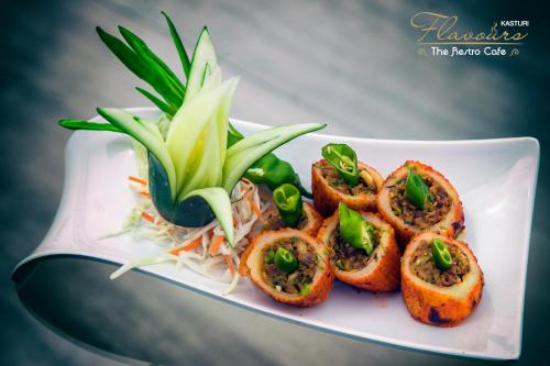 a plate of food with meat and vegetables on it at Hotel Kasturi Orchid in Pāl