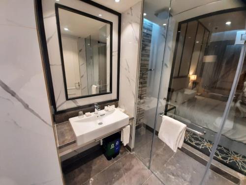 a bathroom with a sink and a mirror and a shower at Hotel Polo Towers Agartala in Agartala