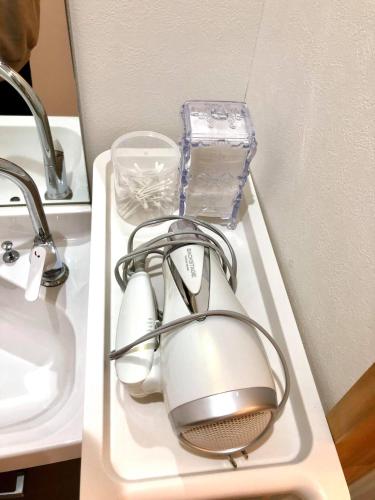 a tea pot on a tray next to a sink at The Little Garden in Miyazaki