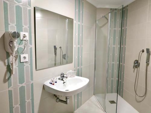 a bathroom with a sink and a shower at Hotel Los Conejos in Mora