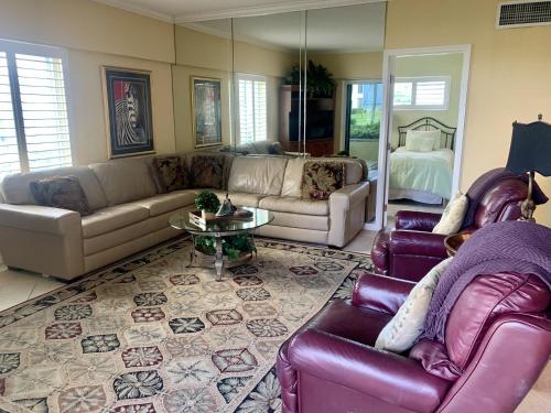 a living room with two couches and a table at Island House Beach Resort 10S in Point O'Rocks