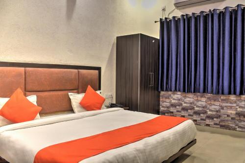 a bedroom with a large bed with orange pillows at HOTEL HILL VIEW in Dehradun