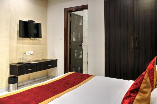 a hotel room with a bed and a tv at HOTEL HILL VIEW in Dehradun
