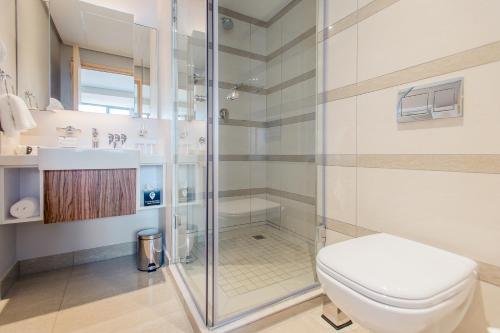 a bathroom with a shower and a toilet at The Capital Pearls Hotel in Durban