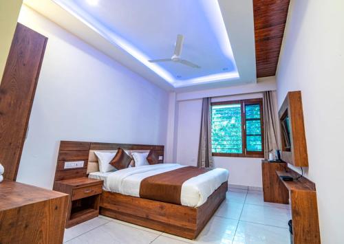 a bedroom with a bed and a television in it at Hotel Divine Residency by VARSHRI in Haridwār