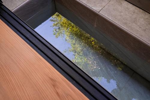 a window in a building with a reflection of a tree at Hakuunsou in Yugawara