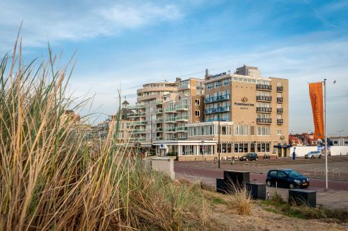 ein großes Gebäude mit einem davor geparkt in der Unterkunft Prominent Inn Hotel in Noordwijk aan Zee
