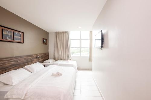 a hotel room with two beds and a window at BG Business Hotel in Bukit Mertajam