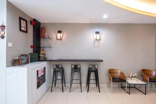 a bar in a restaurant with stools and a counter at BG Business Hotel in Bukit Mertajam