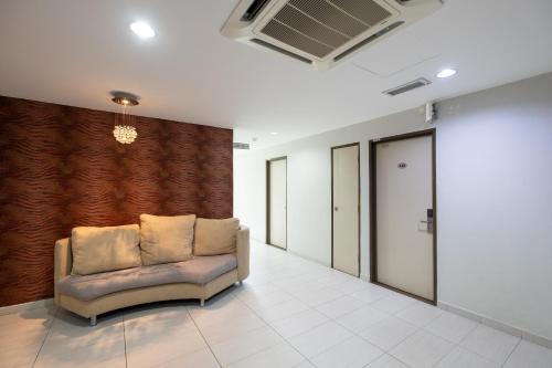 a couch in a room with a wall at BG Business Hotel in Bukit Mertajam