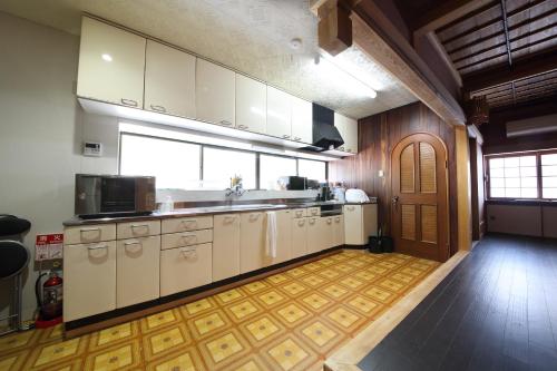 uma grande cozinha com armários brancos e uma grande janela em 宍粟片山 em Shiso