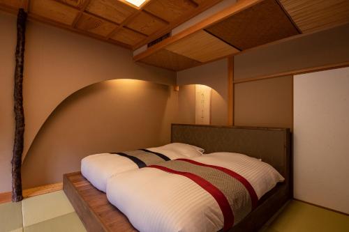 a bedroom with a bed in a room with a ceiling at Hakuunsou in Yugawara