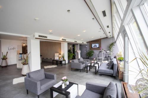 a living room with couches and chairs in a building at Das Loft Hotel Willingen in Willingen