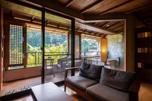 a living room with a couch and a large window at Hakuunsou in Yugawara