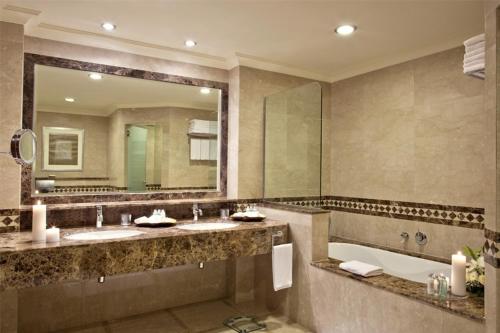 baño con 2 lavabos y espejo grande en Miramar Al Aqah Beach Resort en Al Aqah