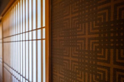a room with a window and a wall with a pattern at Hakuunsou in Yugawara