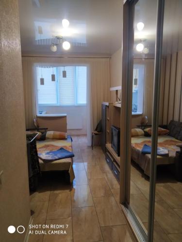 Zimmer mit 2 Betten und einem Spiegel in der Unterkunft Солнечная in Kharkov