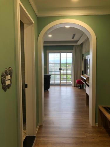 a hallway with green walls and an archway with a door at Dafu Qiandai Manor in Zhuangwei