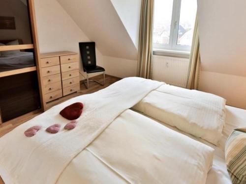 ein Schlafzimmer mit einem weißen Bett mit zwei Herzen darauf in der Unterkunft Ostseefeeling - lichtdurchflutete Ferienwohnung - (App.37) in Timmendorfer Strand