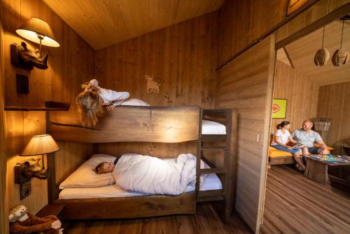 a bunk bed with two men sleeping on it at Serengeti Park Resort in Hodenhagen
