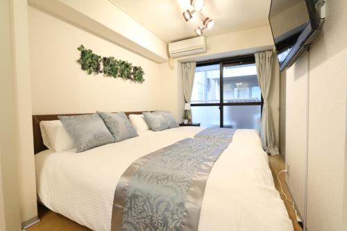 une chambre avec un grand lit et une fenêtre dans l'établissement Elizabeth Garden II, à Osaka