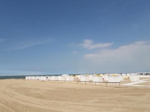 een rij witte strandhutten op het strand bij Studio spacieux 50 m2 pour 2+2 tout confort in Knokke-Heist