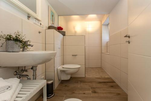 キュールングスボルンにあるHaus-Krischanweg-WE-1-9920の白いバスルーム(洗面台、トイレ付)