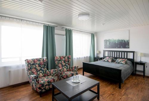 リガにあるHotel Mezaparksのベッドルーム1室(ベッド1台、椅子、テーブル付)