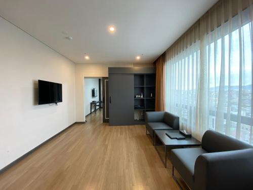 sala de estar con sofá y TV en Hotel Daoom, en Ulsan