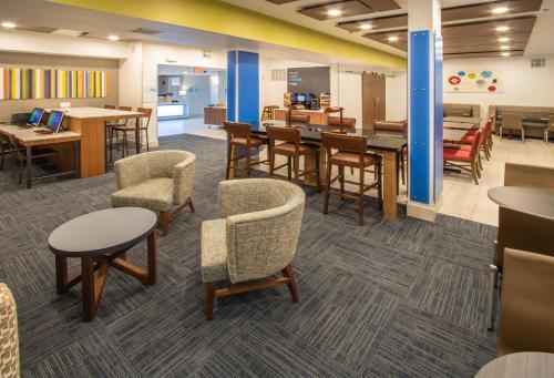 a waiting room with tables and chairs and a cafeteria at Holiday Inn Express Hotel & Suites Roseville - Galleria Area, an IHG Hotel in Roseville