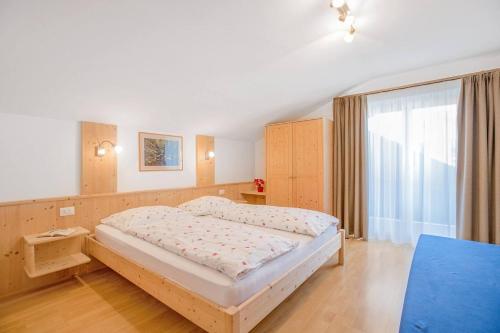 1 dormitorio con cama y ventana grande en Residence krUma, en Valdaora