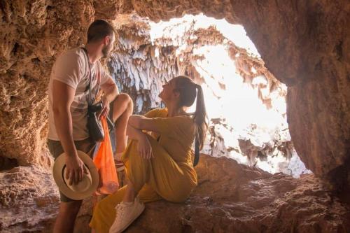 a man and a woman sitting in a cave at Le petit Jardin in Demnat
